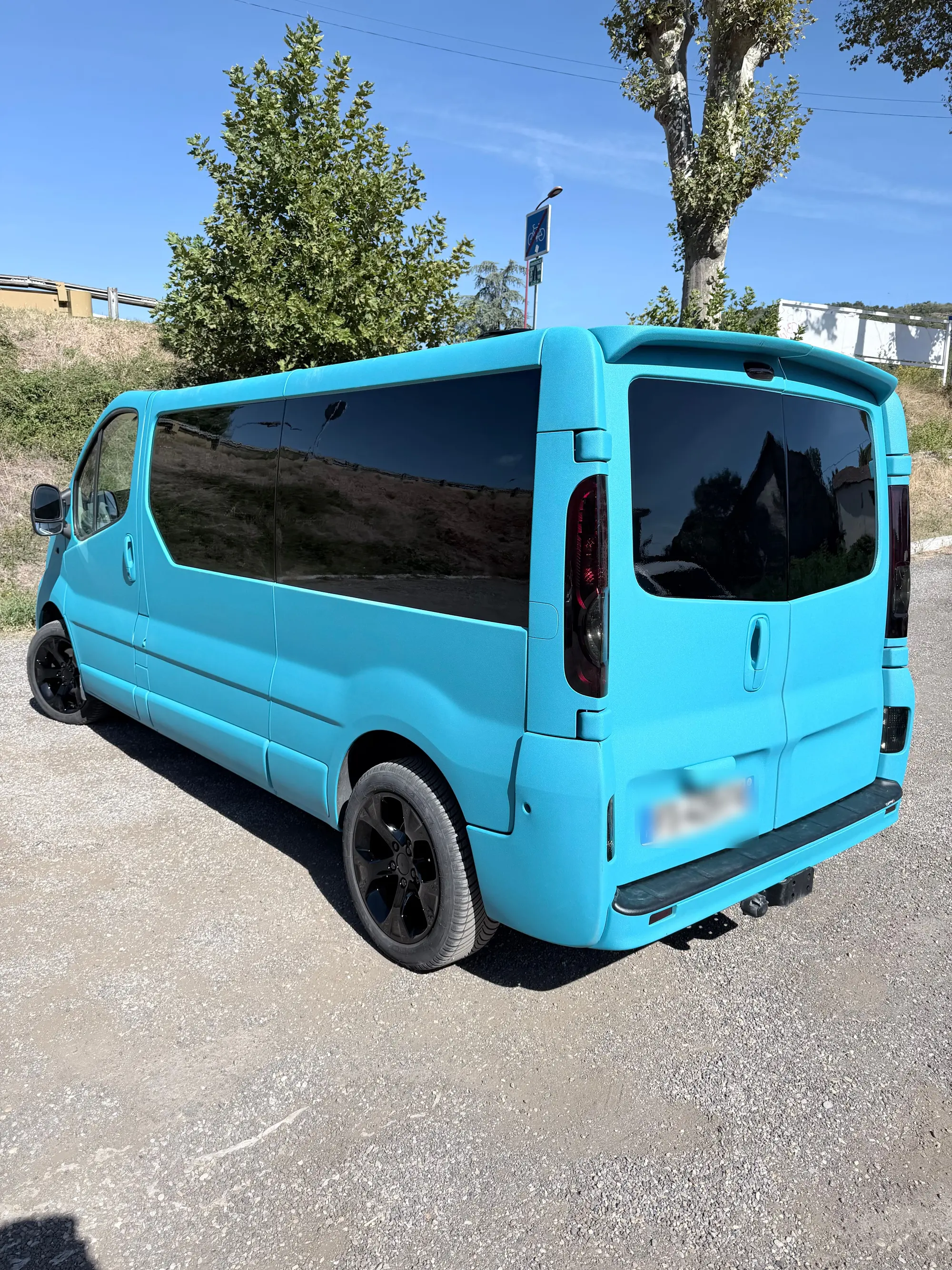 Fourgon aménagé peint en turquoise, jantes noires et vitres teintées