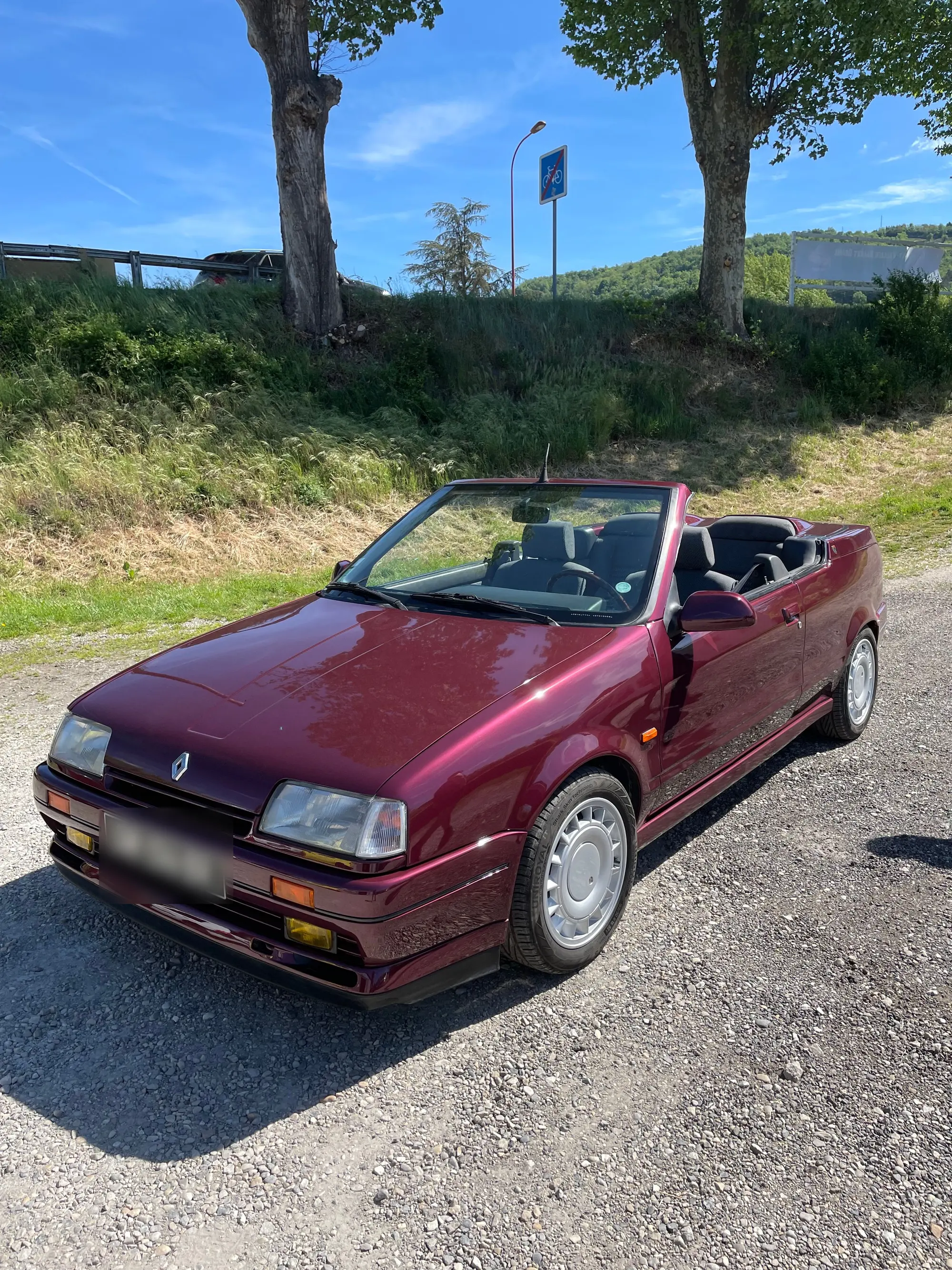 Renault 19 cabriolet bordeaux nacré, capote ouverte, en plein soleil